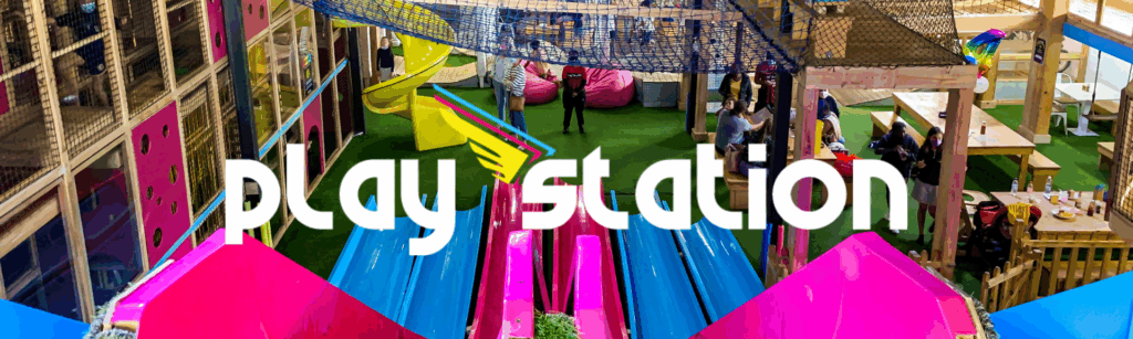 Colorful indoor play area at PlayStation by Rush, featuring vibrant slides, play structures, and children enjoying various activities.