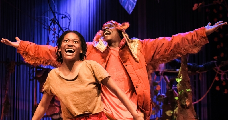 Actors performing in The Jungle Book, with vibrant costumes and lively stage action.