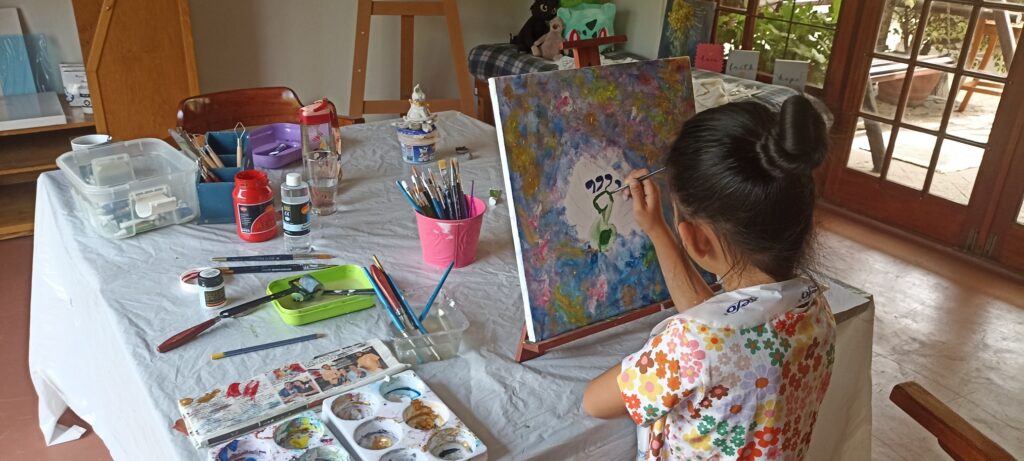 Child painting on canvas during a kids art class in Durbanville at Art with Kay.