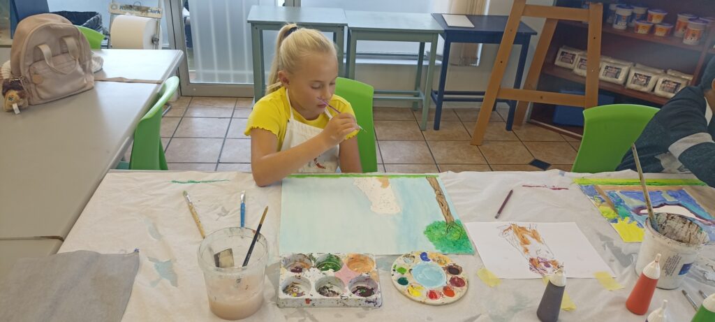 Child painting a canvas during a kids art class in Durbanville at Art with Kay.