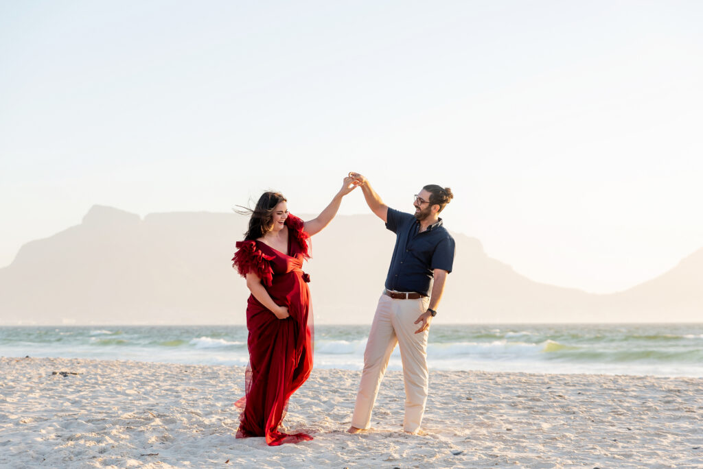 Expectant couple holding hands on the beach during a maternity family photo session by Chasing Light Photography.
