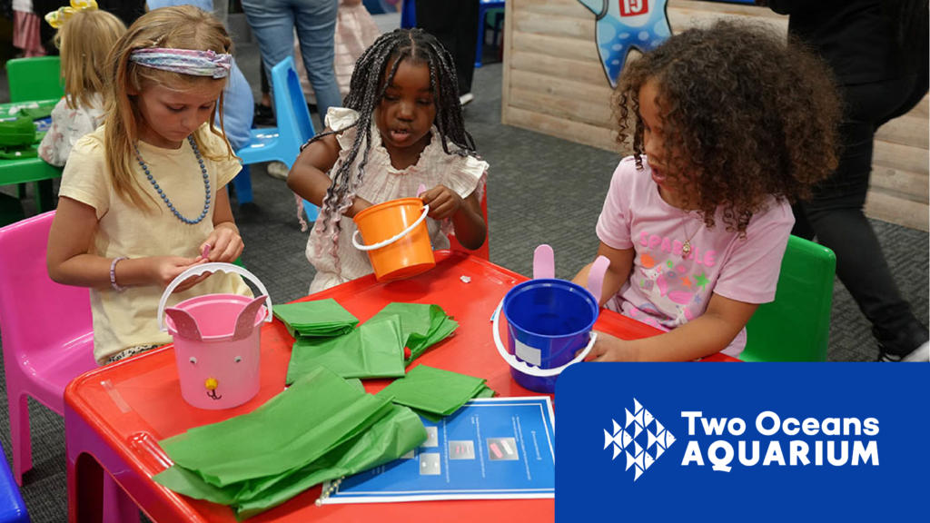 Two Oceans Aquarium family activity image showing children doing a creative ocean-themed craft at a colourful table.